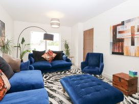 A living room with blue furniture and a painting at Manor Park View in Norwich