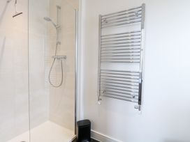 A bathroom with a shower and towel rail at Manor Park View in Norwich
