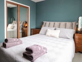 A bedroom with a bed and nightstands at Manor Park View in Norwich