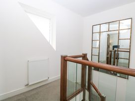 A hallway with a mirror and window at Manor Park View in Norwich