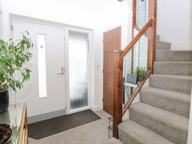 A hallway with a door and staircase at Manor Park View in Norwich
