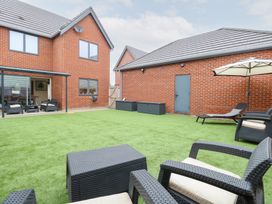 A garden with seating and lawn at Manor Park View in Norwich
