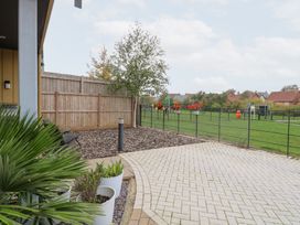 An outdoor patio area with planters and a view of a playground at Manor Park View in Norwich