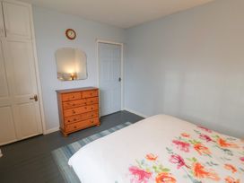 A bedroom with a bed and a wooden dresser at Cromer Holiday Home in Cromer