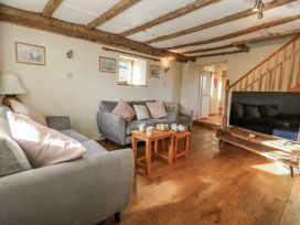 A living room with a sofa and television at Honeysuckle Cottage in Smallridge Nr. Axminster