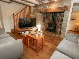 A living room with a television and fireplace at Honeysuckle Cottage, Smallridge Nr. Axminster