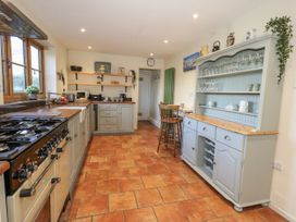 A kitchen with a stove and cabinet at Honeysuckle Cottage in Smallridge Nr. Axminster