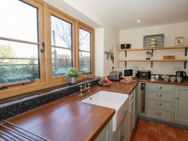 A kitchen with wooden countertops and a sink at Honeysuckle Cottage in Smallridge Nr. Axminster