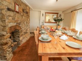 A dining room with a wooden table set for a meal at Honeysuckle Cottage in Smallridge Nr. Axminster