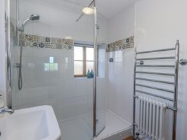 A bathroom with a shower and towel rack at Honeysuckle Cottage Smallridge Nr. Axminster