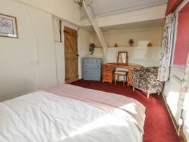 A bedroom with a bed, wardrobe, and dresser at Honeysuckle Cottage in Smallridge Nr. Axminster