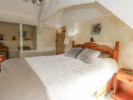 A bedroom with a bed and wooden furnishings at Honeysuckle Cottage in Smallridge Nr. Axminster