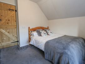 A bedroom with a bed and wooden door at Honeysuckle Cottage Smallridge Nr. Axminster