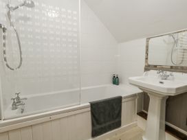A bathroom featuring a bathtub and sink at Honeysuckle Cottage in Smallridge Nr. Axminster