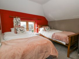 A bedroom with two beds and a window at Honeysuckle Cottage Smallridge Nr. Axminster
