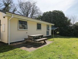 A house with a picnic table and clothesline in the garden at Willow Lodge Liskeard