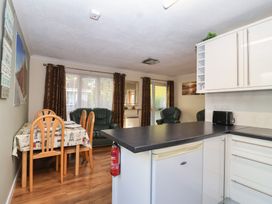 A kitchen with a dining table and chairs at Willow Lodge Rosecraddoc Lodge near Liskeard