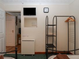 A bedroom with a television and a shelf at Willow Lodge near Liskeard