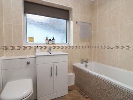 A bathroom with a bathtub and washbasin at Willow Lodge near Liskeard