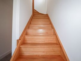 A staircase with wooden steps and a white wall at Barn 5