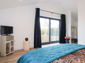 A bedroom with a television and window at Barn 5 