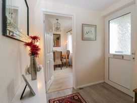 A hallway with a mirror and flowers at Apple Byrd in Kendal