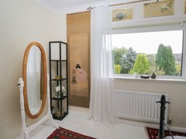 A bedroom with a mirror and decorative screen at Apple Byrd in Kendal