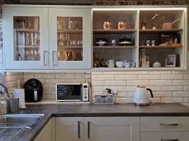 A kitchen with cabinets and appliances at Apple Byrd in Kendal