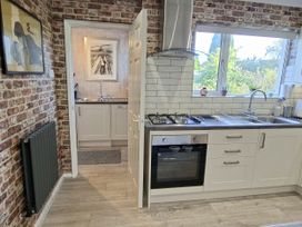 A kitchen with an oven and sink at Apple Byrd in Kendal