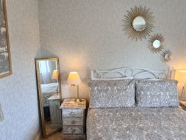 A bedroom with a bed and mirror at Apple Byrd in Kendal