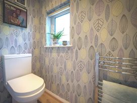 A bathroom with a toilet and a window at Apple Byrd in Kendal