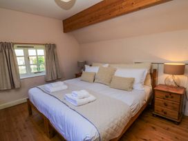A bedroom with a bed and nightstand at Plush Cottage in Dorchester