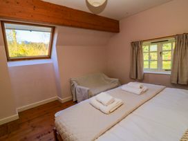 A bedroom with a bed and a sofa at Plush Cottage in Dorchester