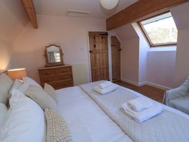 A bedroom with a bed and dresser at Plush Cottage in Dorchester