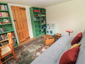 A snug with bookshelves and a play kitchen at Plush Cottage in Plush