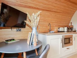 A kitchen with a table and a television at Barry in Polgooth