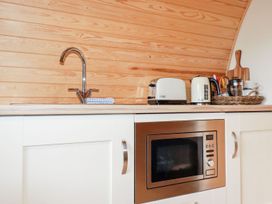 A kitchen with sink toaster kettle and microwave at Barry in Polgooth