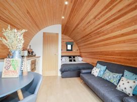 A studio with wood paneling and furniture at Sam in Polgooth
