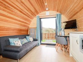 A living room with a sofa and dining area at Sam in Polgooth