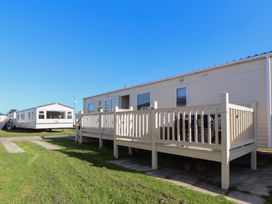 A mobile home with a deck and chairs at The Pad in 