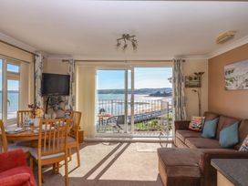 A living room with a sofa and dining set at Beachside