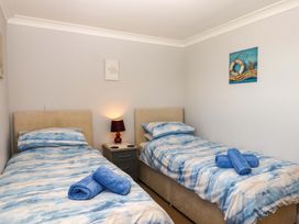 A bedroom with two beds and a bedside table at Beachside