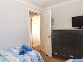 A bedroom with a bed and a dresser at Beachside