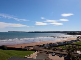 A beach with people and beach huts at Beachside in 