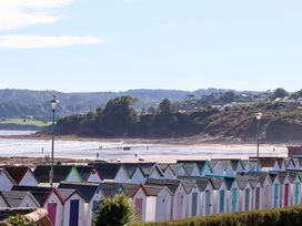 A view of beach huts and a beach with people at Beachside in 