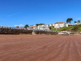 A beach with beach huts and buildings in the background at Beachside