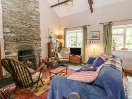 A living room with a fireplace and sofa at Tyn Y Fron in Brynherbert near Llanrhystud