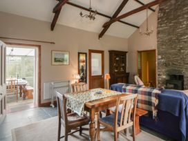 A dining room with a table and chairs at Tyn Y Fron in Brynherbert near Llanrhystud