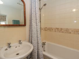 A bathroom with a bathtub and sink at Tyn Y Fron in Brynherbert near Llanrhystud