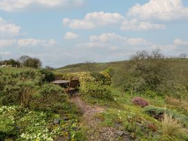 A garden with a table and chairs at Tyn Y Fron Brynherbert near Llanrhystud